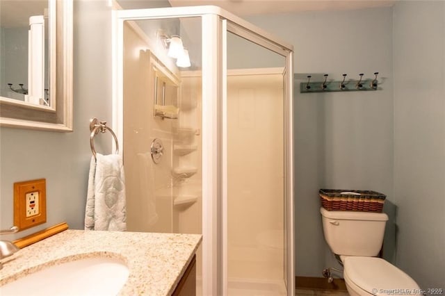 full bath featuring a stall shower, vanity, and toilet