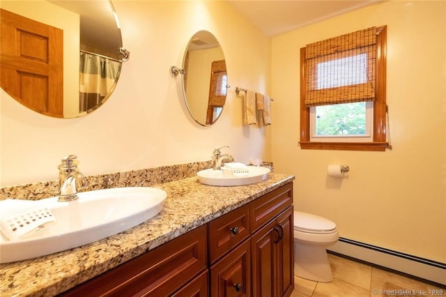 bathroom featuring double vanity, a baseboard radiator, toilet, a sink, and tile patterned floors