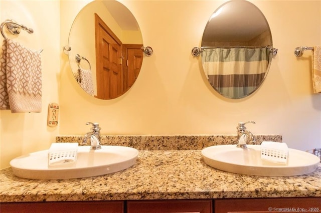 full bathroom with double vanity and a sink