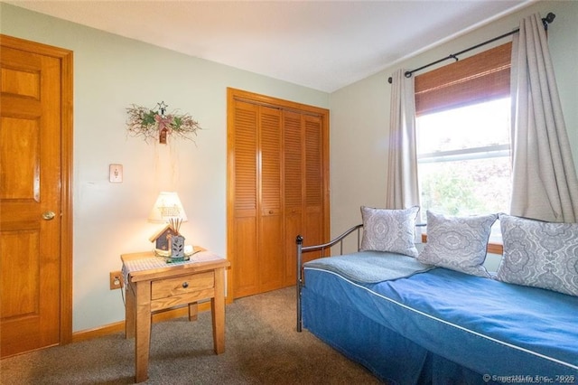 carpeted bedroom featuring baseboards and a closet