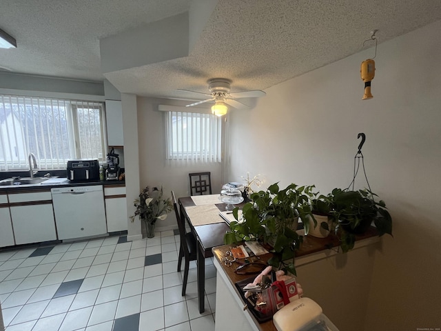 kitchen featuring ceiling fan, a sink, white cabinetry, dishwasher, and dark countertops