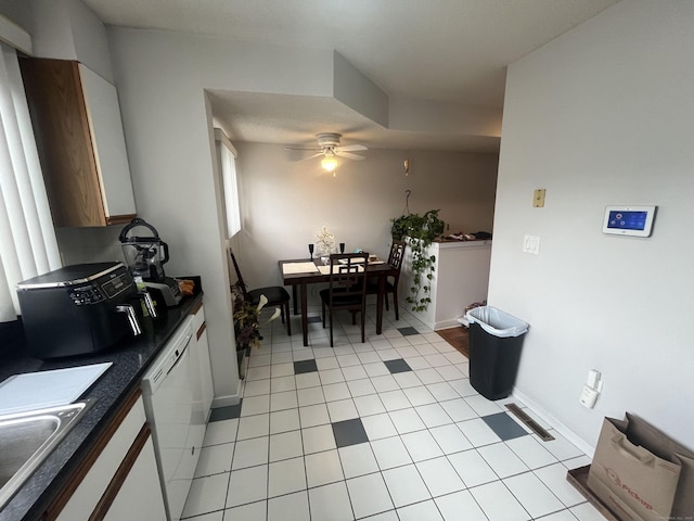 kitchen featuring dark countertops, visible vents, a sink, ceiling fan, and dishwasher