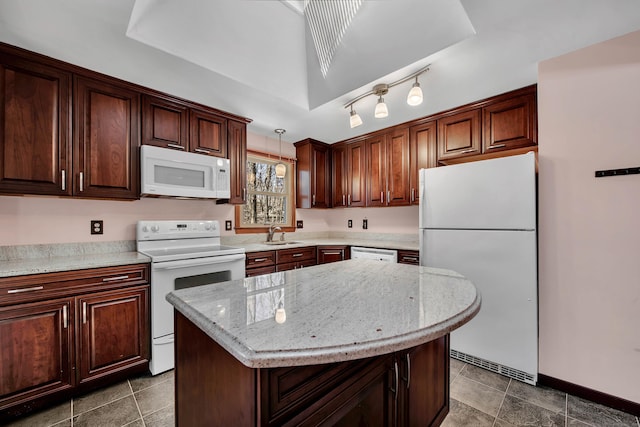 kitchen featuring a kitchen island, a sink, light stone countertops, white appliances, and baseboards