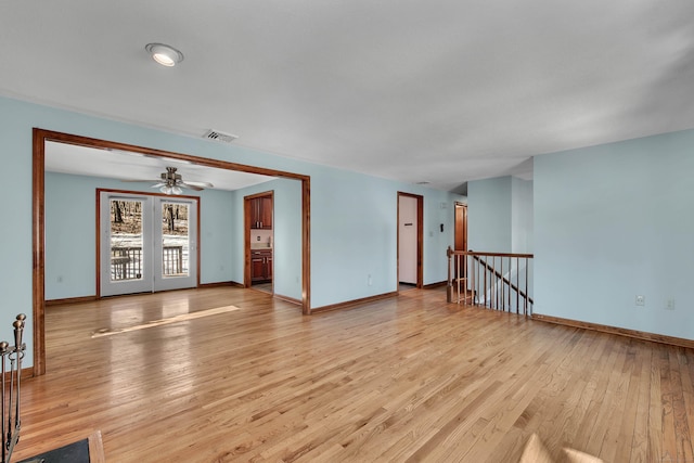 empty room featuring light wood-style floors, visible vents, and baseboards