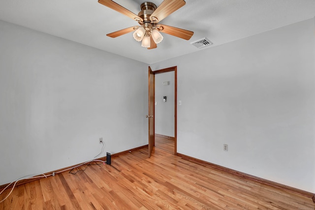 empty room with baseboards, light wood-style flooring, visible vents, and a ceiling fan