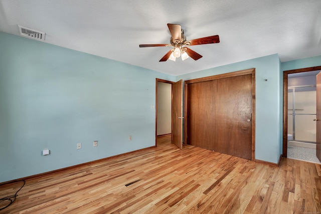 unfurnished bedroom with a closet, visible vents, ceiling fan, wood finished floors, and baseboards