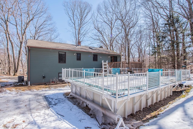 rear view of house with a covered pool, fence, a chimney, and a wooden deck