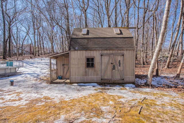 snow covered structure with an outbuilding