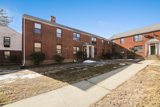 exterior space featuring brick siding and a chimney