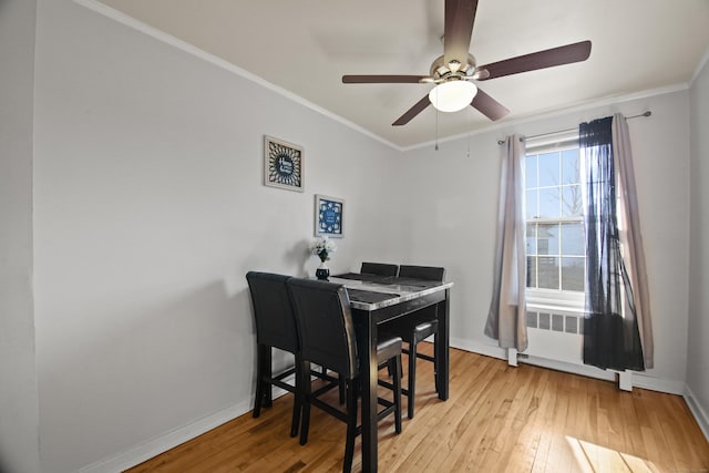 office area featuring hardwood / wood-style flooring, a ceiling fan, baseboards, ornamental molding, and radiator