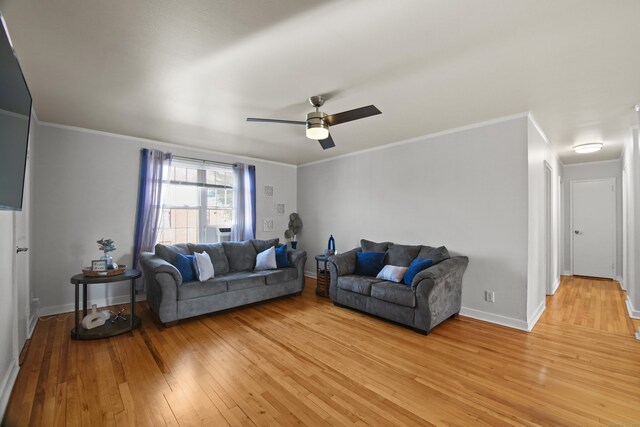 living room with light wood-style floors, baseboards, ornamental molding, and ceiling fan