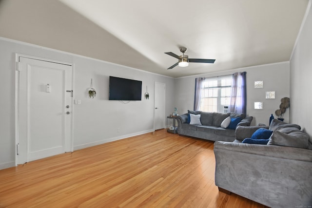 living room featuring ceiling fan, ornamental molding, light wood-style flooring, and baseboards