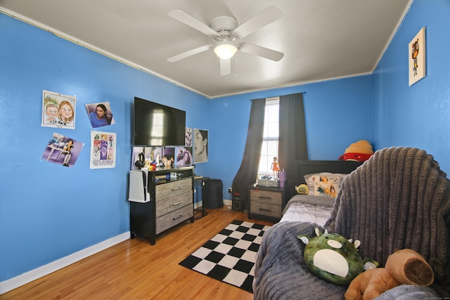 bedroom with light wood-type flooring, crown molding, baseboards, and ceiling fan