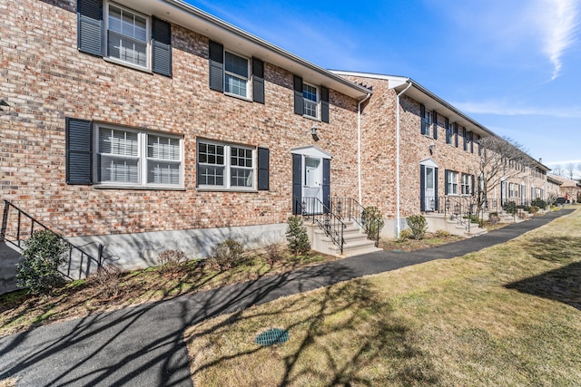 view of front of home featuring a front lawn and brick siding