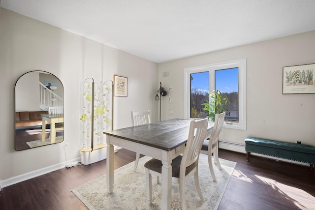 dining space featuring baseboards and wood finished floors