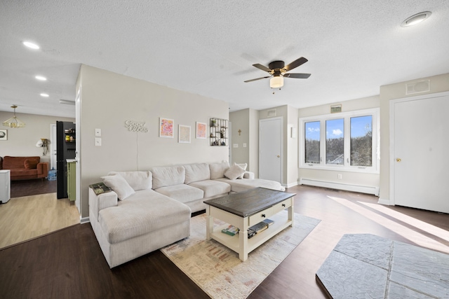 living room with a baseboard heating unit, ceiling fan, recessed lighting, wood finished floors, and a textured ceiling