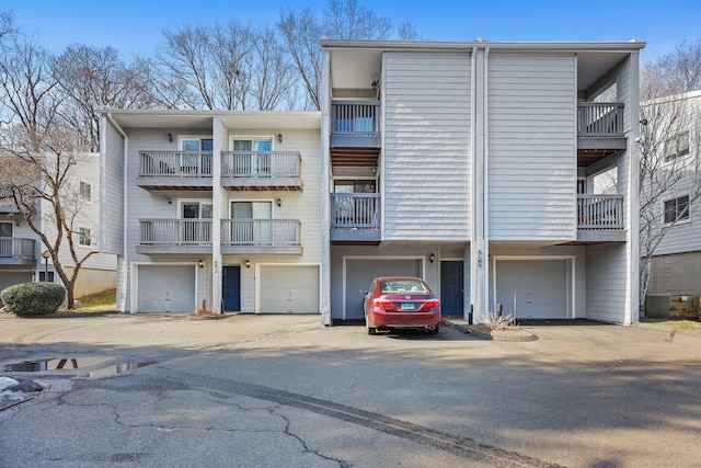 view of building exterior with a garage and central AC unit