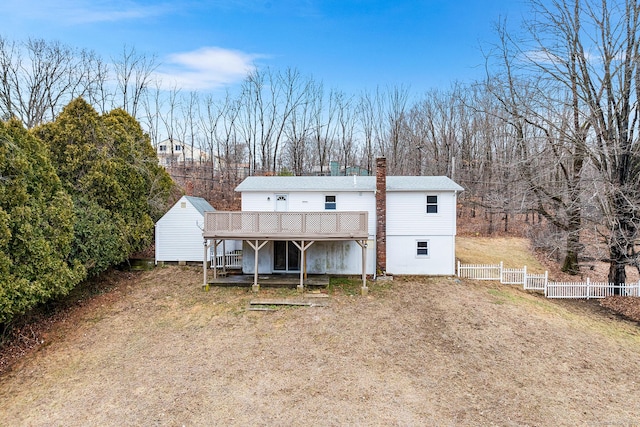 back of property featuring a deck and fence