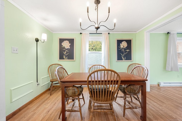 dining room with light wood-type flooring, a baseboard radiator, a notable chandelier, and crown molding