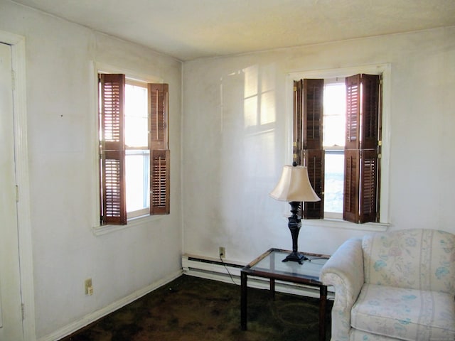 sitting room featuring baseboards and plenty of natural light