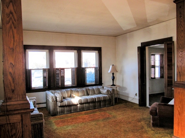 carpeted living area with a baseboard heating unit and baseboards