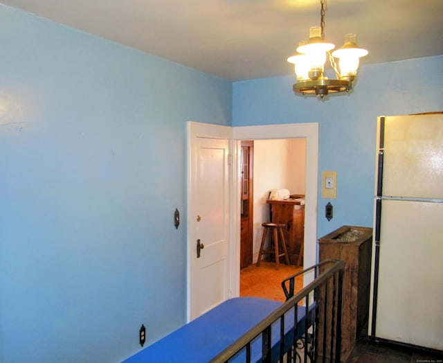 interior space featuring a chandelier and freestanding refrigerator