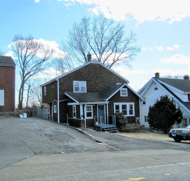 view of front of house featuring fence and a chimney