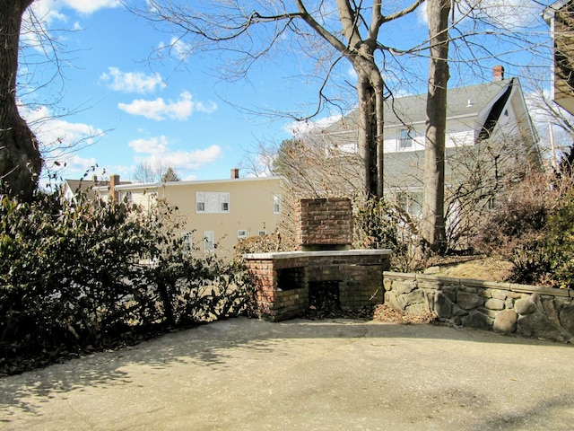 view of patio featuring an outdoor brick fireplace