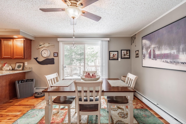 dining area with crown molding, a baseboard radiator, a baseboard heating unit, a textured ceiling, and light wood-type flooring