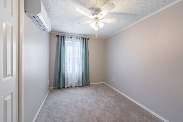 spare room featuring carpet, an AC wall unit, ceiling fan, a textured ceiling, and baseboards