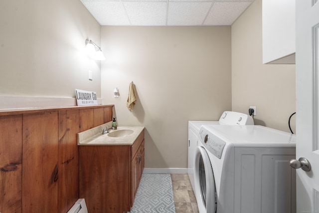 laundry room with cabinet space, baseboards, separate washer and dryer, and a sink