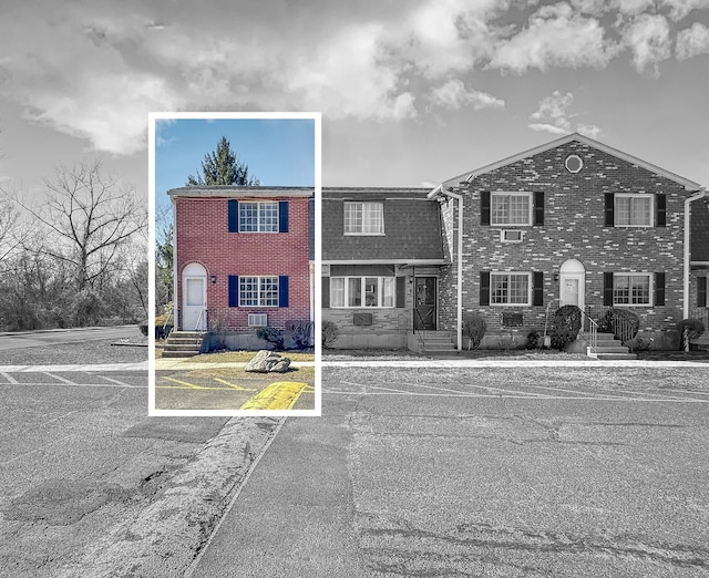 view of front of property with brick siding and uncovered parking