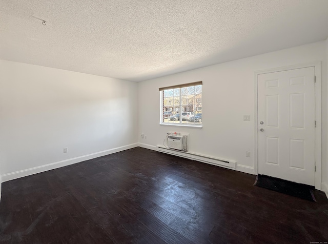 empty room with a wall mounted air conditioner, a textured ceiling, a baseboard radiator, baseboards, and dark wood-style flooring