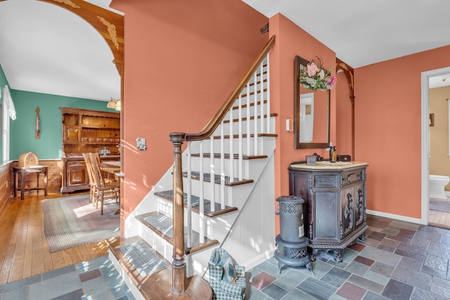 stairs with baseboards and stone tile flooring