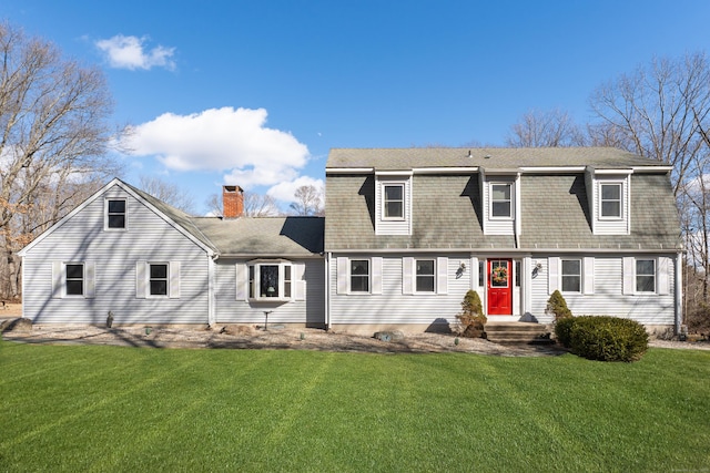 dutch colonial featuring a front lawn, a chimney, and a shingled roof