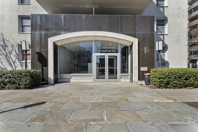 property entrance featuring brick siding and french doors