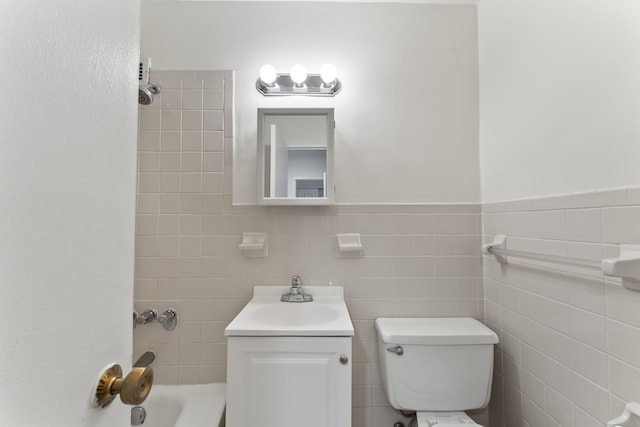 full bathroom featuring a wainscoted wall, toilet, shower / washtub combination, tile walls, and vanity