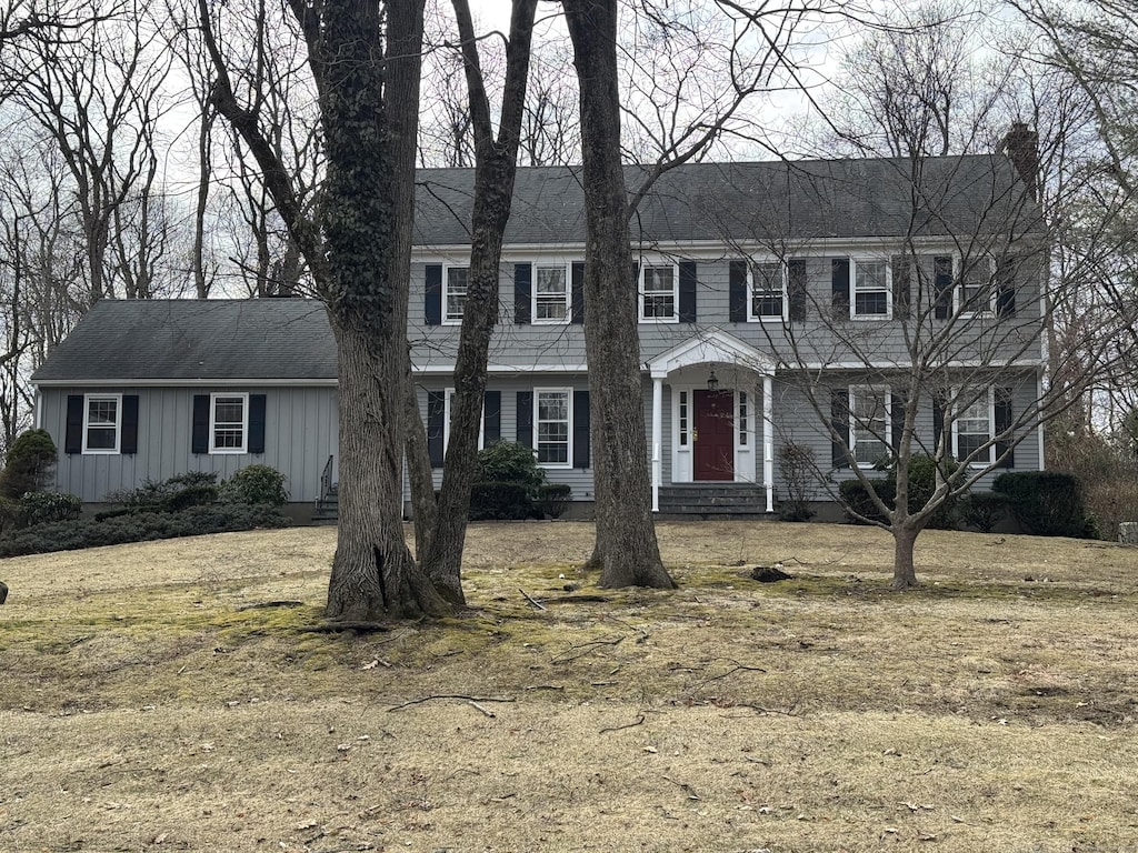 colonial home with a chimney and board and batten siding