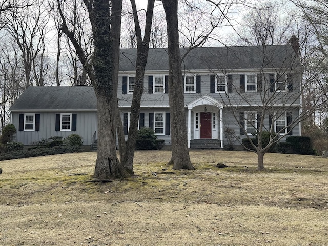 colonial home with a chimney and board and batten siding