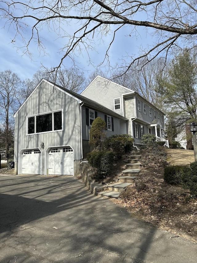 view of property exterior featuring board and batten siding, driveway, and an attached garage