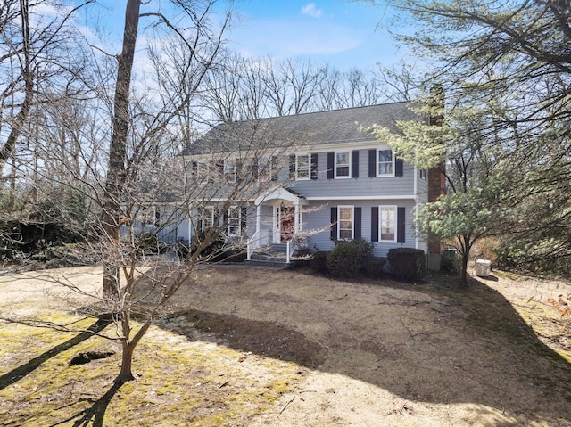 colonial home featuring a shingled roof