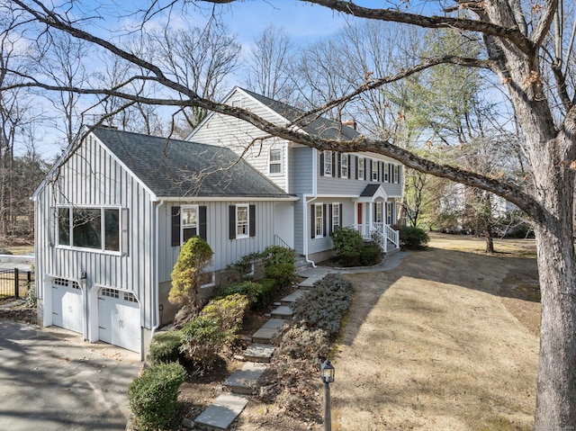 view of front of property featuring aphalt driveway, a garage, board and batten siding, and a shingled roof