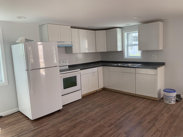 kitchen with white appliances, dark countertops, under cabinet range hood, and a sink
