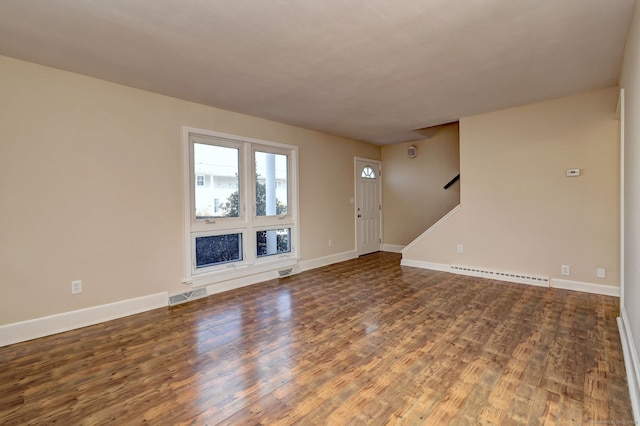 unfurnished living room with visible vents, stairs, a baseboard heating unit, and wood finished floors