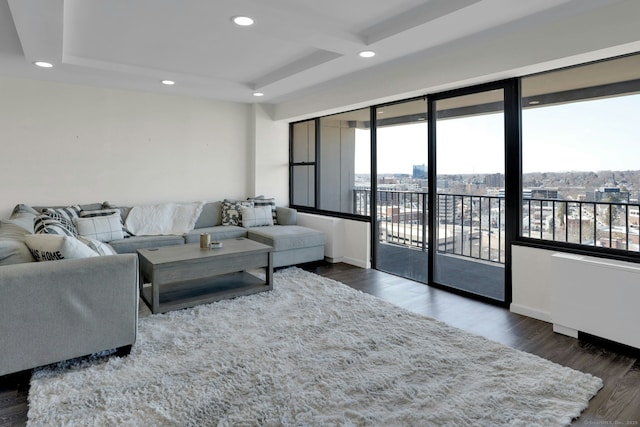 living area with a city view, recessed lighting, coffered ceiling, wood finished floors, and baseboards