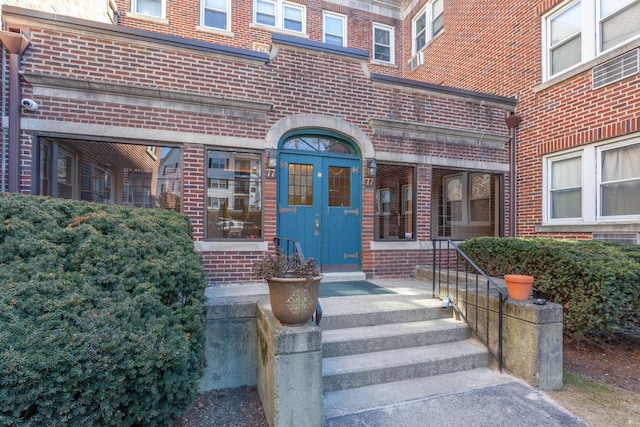 doorway to property featuring brick siding