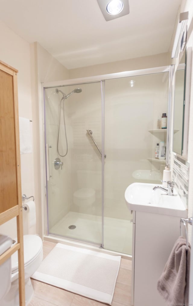 full bath with a shower stall, toilet, and vanity