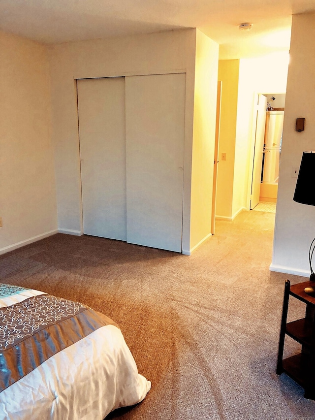 bedroom with carpet, baseboards, and a closet