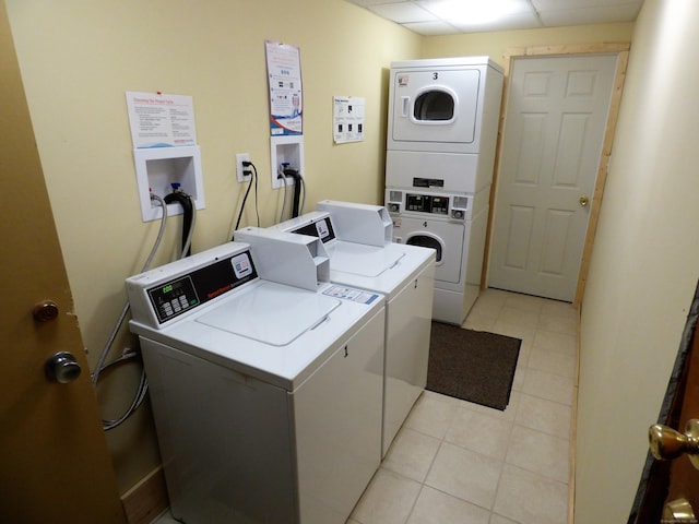 common laundry area featuring washing machine and dryer, stacked washer / drying machine, and light tile patterned flooring