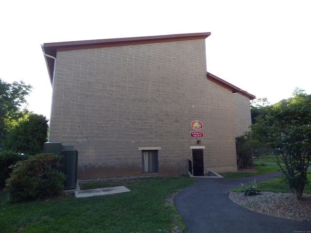 view of side of property with a lawn and brick siding